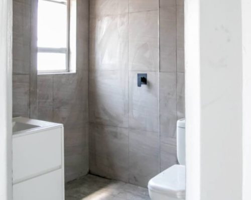 48 Sets Custom Cabinets for Ongwe Holiday Apartment Decoration in Namibia 2 Modern bathroom design with shower and white cabinet in Ongwe Apartment project.
