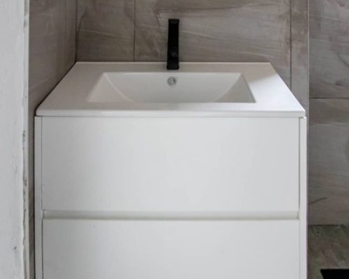 48 Sets Custom Cabinets for Ongwe Holiday Apartment Decoration in Namibia 3 Custom bathroom vanity with sleek black faucet in Ongwe Apartment bathroom.