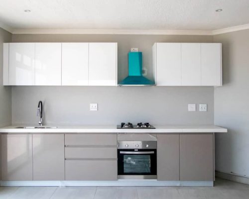 48 Sets Custom Cabinets for Ongwe Holiday Apartment Decoration in Namibia 4 Sleek and modern kitchen cabinets for Ongwe Apartment featuring white and beige tones.
