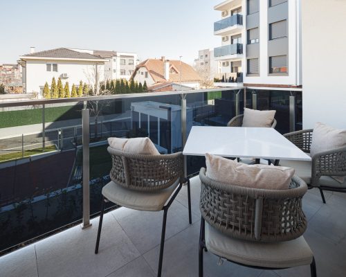 Zemun Stan Whole House custom in Serbia 4 Zemun stan apartment balcony with outdoor furniture and a scenic view of the neighborhood.