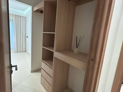 169 Sets Modern Minimalist Apartment Custom Cabinets Project in Dammam 9 Open wardrobe cabinet in Dammam apartment with light wood finish, hanging area, shelving, and drawer storage.